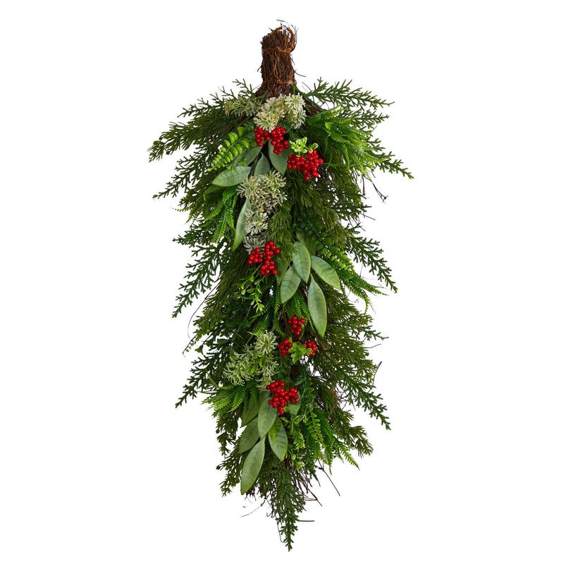 Hanging Christmas swag of fresh evergreen cedar and holly with red berries and mixed greenery for holiday door decoration