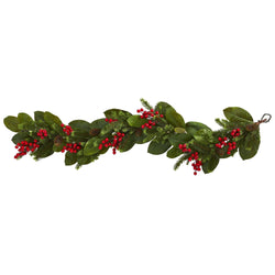 Festive Christmas garland with magnolia leaves, evergreen pine sprigs, red berries and pine cones for mantel and staircase decor