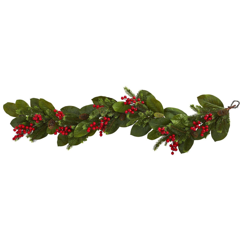 Festive Christmas garland with magnolia leaves, evergreen pine sprigs, red berries and pine cones for mantel and staircase decor