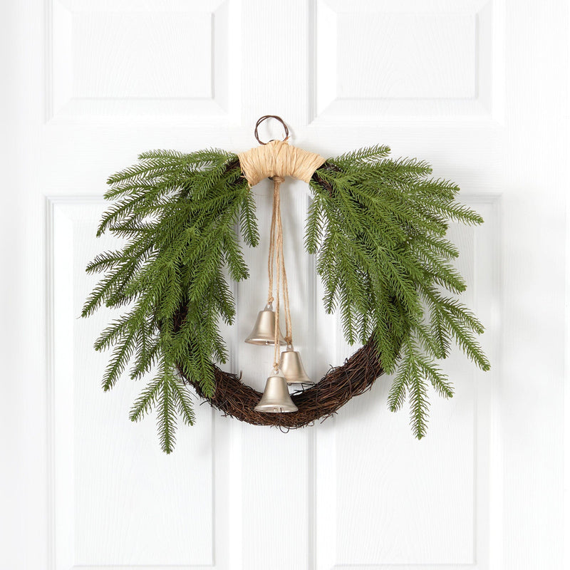 Rustic twig Christmas wreath with cascading evergreen branches and three hanging silver bells on a white paneled door, farmhouse holiday door decor