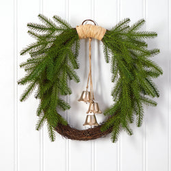 Rustic evergreen grapevine Christmas wreath with hanging brass bells on white paneled door, farmhouse holiday door decor
