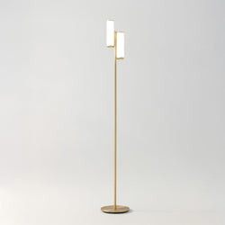 Modern brass gold two-light LED floor lamp with cylindrical white shades on slim stand for minimalist living room lighting