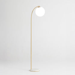 Gold arched floor lamp with white globe shade and marble base, modern minimalist living room lighting