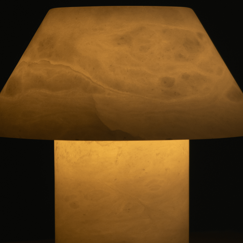 Modern mushroom-shaped alabaster table lamp emitting warm amber glow, minimalist bedside lamp for cozy ambient lighting