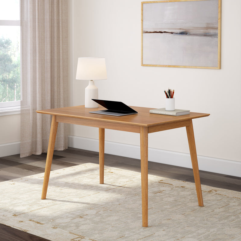 Modern wooden desk with a laptop and lamp in a minimalist home office setting.