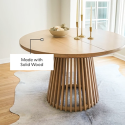 Solid wood round dining table with unique vertical slat base in a modern bright dining room.