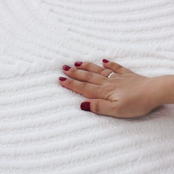 Hand touching soft white textured fabric, highlighting comfort and quality.