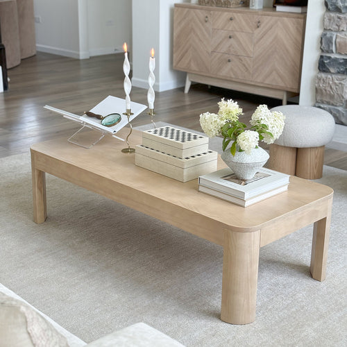 Wooden coffee table with decorative items in a living room setting