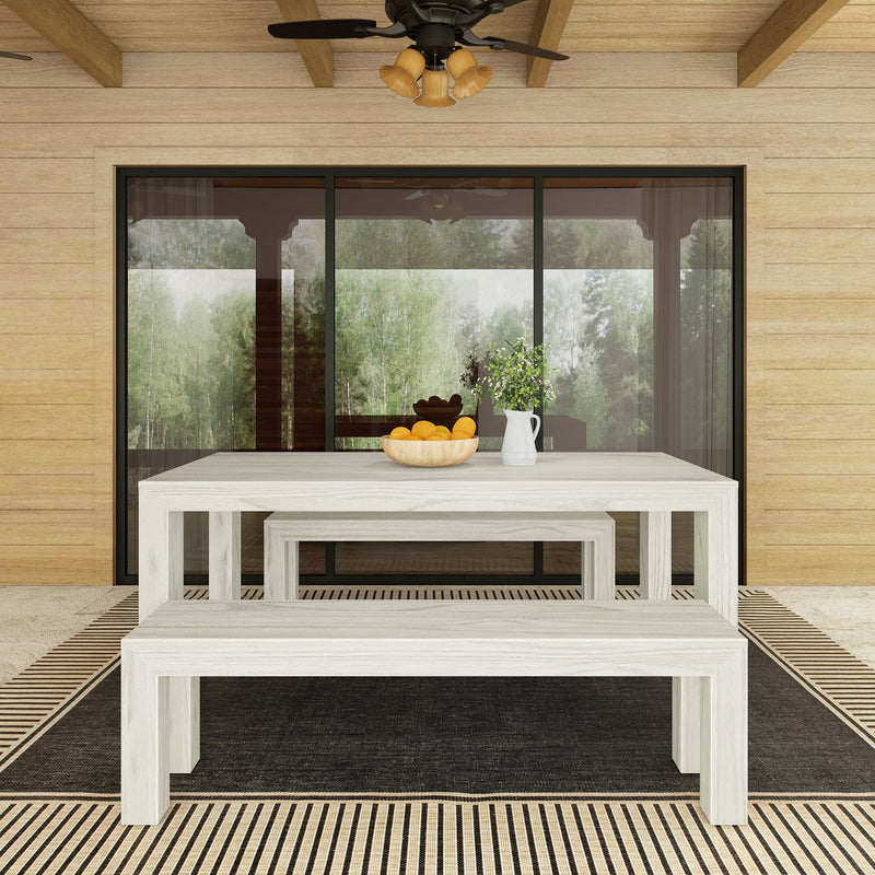 Outdoor patio dining set with a rustic wooden table and benches, decorated with a fruit bowl and vase, under a ceiling fan on a striped rug.