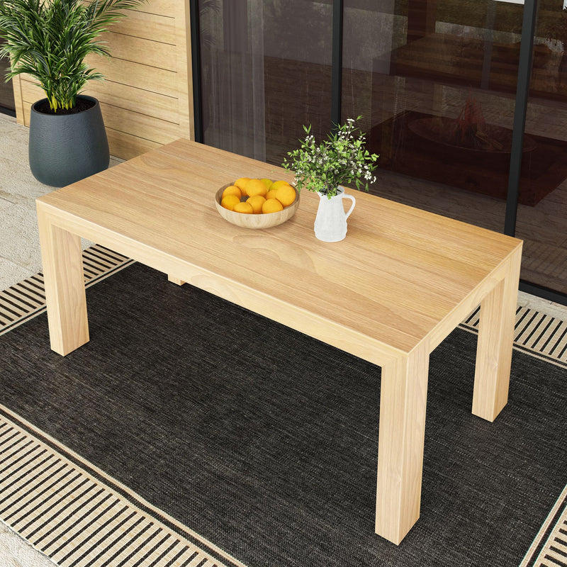 Outdoor wooden patio table with a bowl of oranges and a potted plant, set on a striped rug.