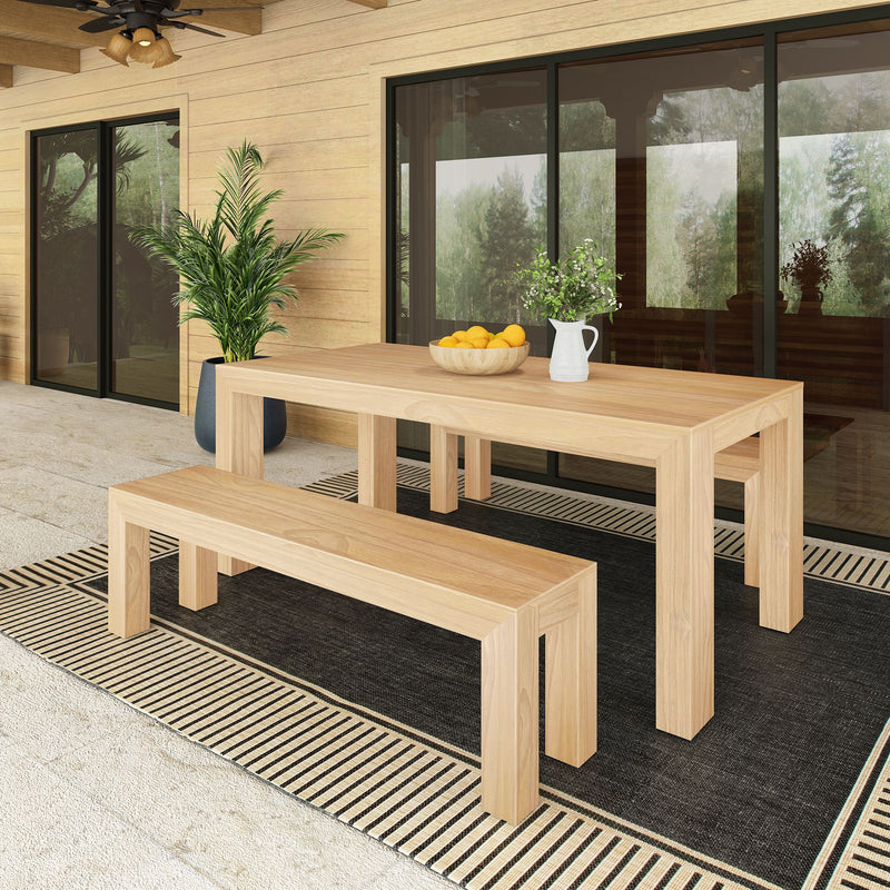 Modern outdoor patio with wooden dining table and benches, potted plant decor, and sliding glass doors.