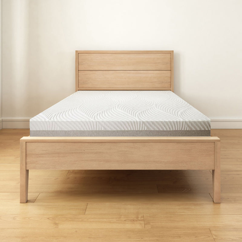 Wooden bed frame with plush mattress in minimalist bedroom setting.