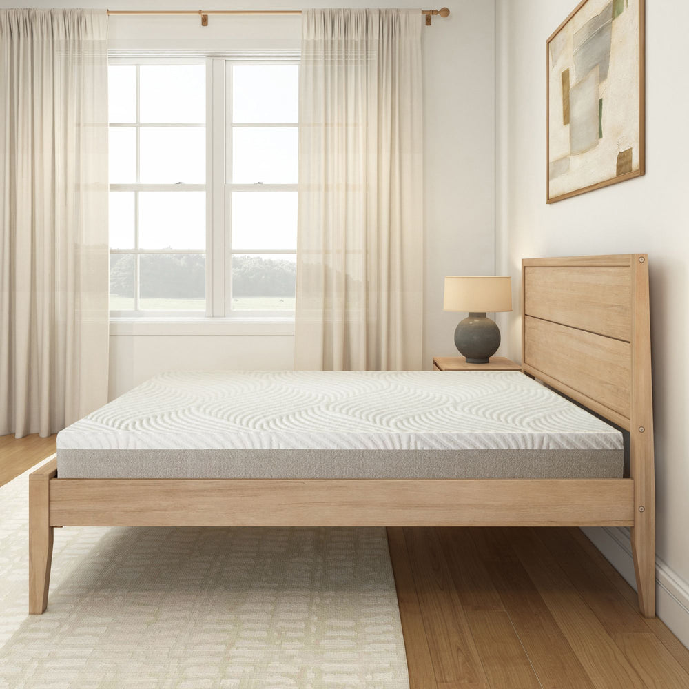 Modern minimalist bedroom with wooden bed frame, comfortable mattress, and soft natural light through curtains.