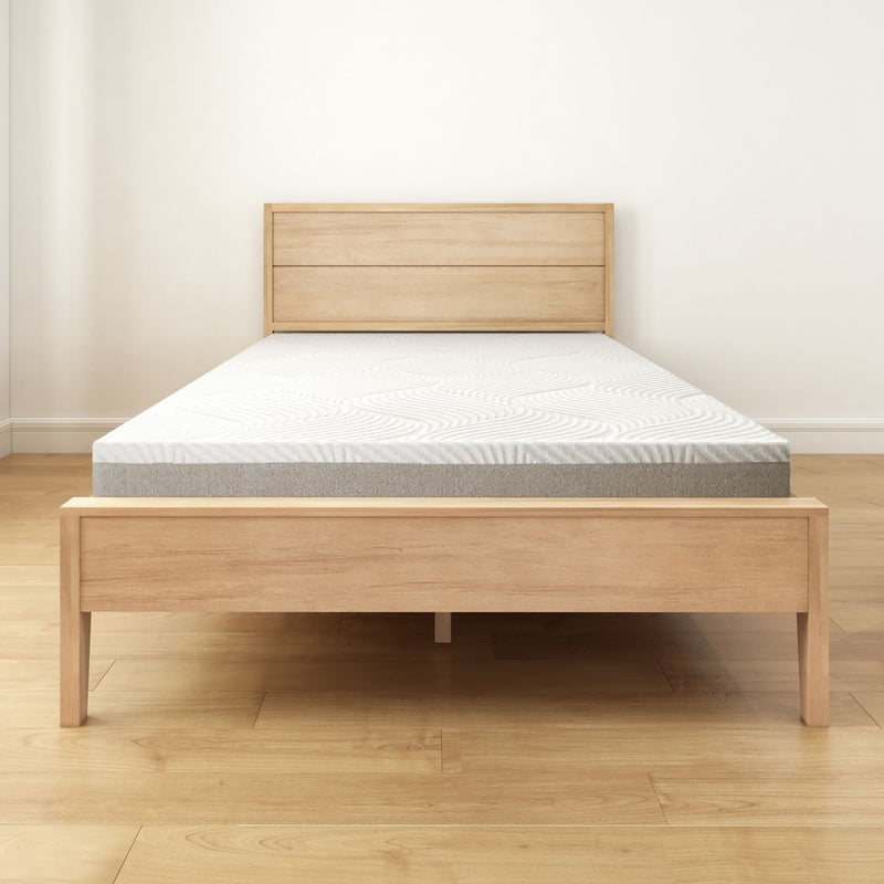 Minimalist beige wooden bed frame with a comfortable memory foam mattress in a bright bedroom.