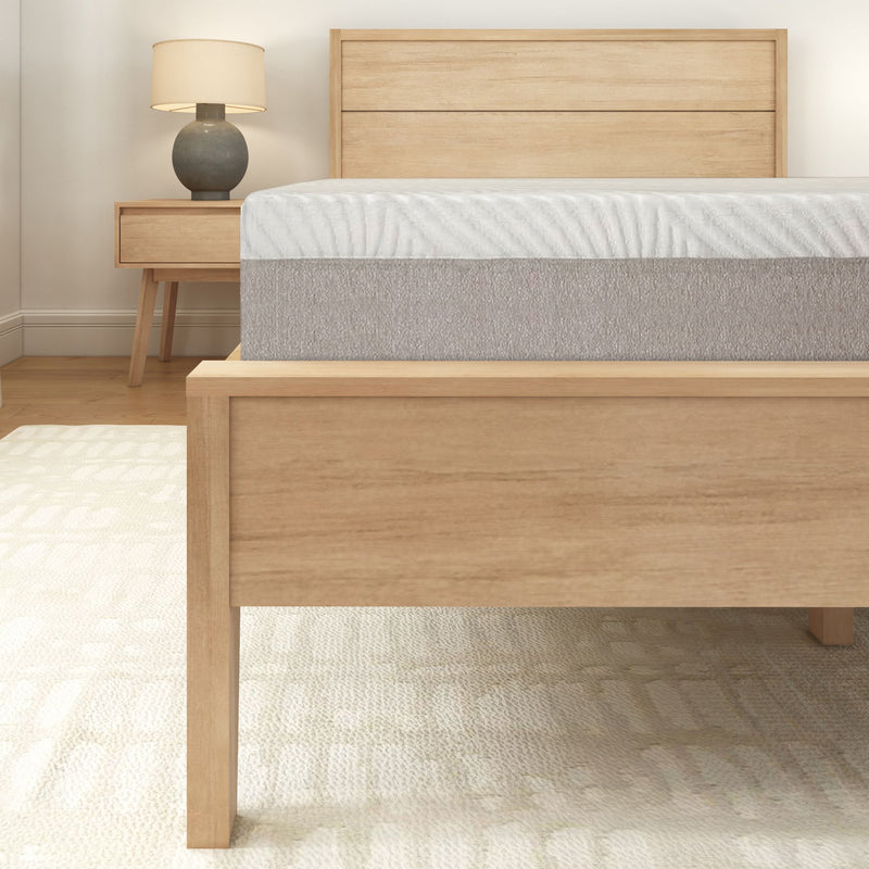 Modern wooden bed frame with a comfortable mattress and bedside table in a stylish bedroom.