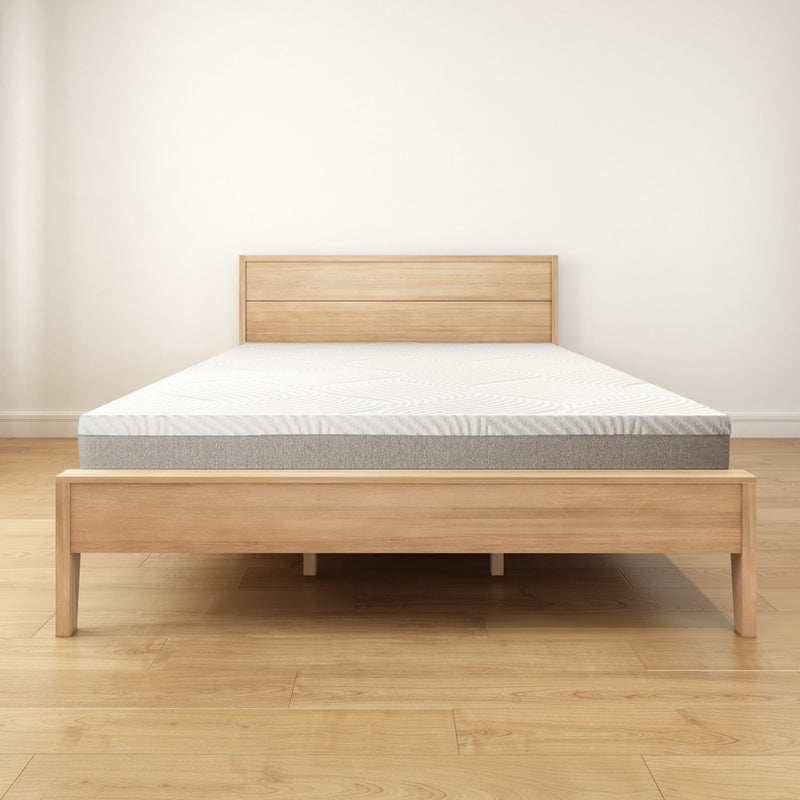 Modern wooden bed frame with mattress in minimalist bedroom setting.