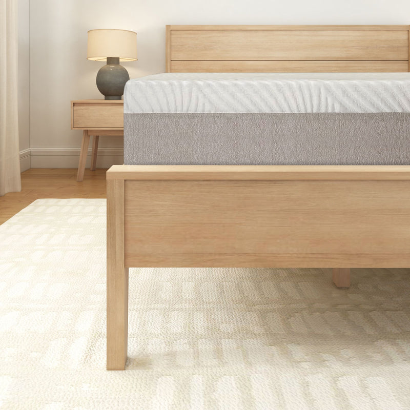 Modern bedroom featuring a wooden bed frame and nightstand with a table lamp.