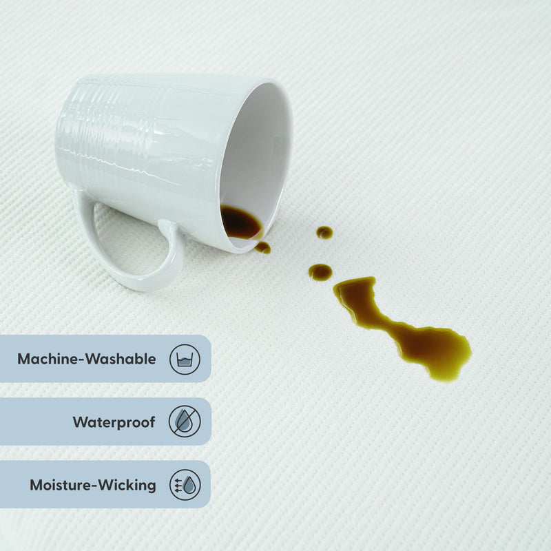 White cup spilling coffee on a waterproof, machine-washable moisture-wicking surface.