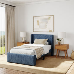 Elegant bedroom with blue upholstered bed, wooden nightstands, and minimalist decor for a modern aesthetic.