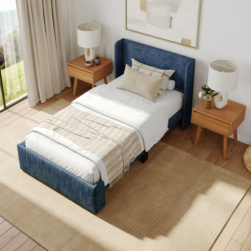 Contemporary bedroom with a blue upholstered bed, beige bedding, wooden side tables, and modern lamps for a cozy and stylish decor.