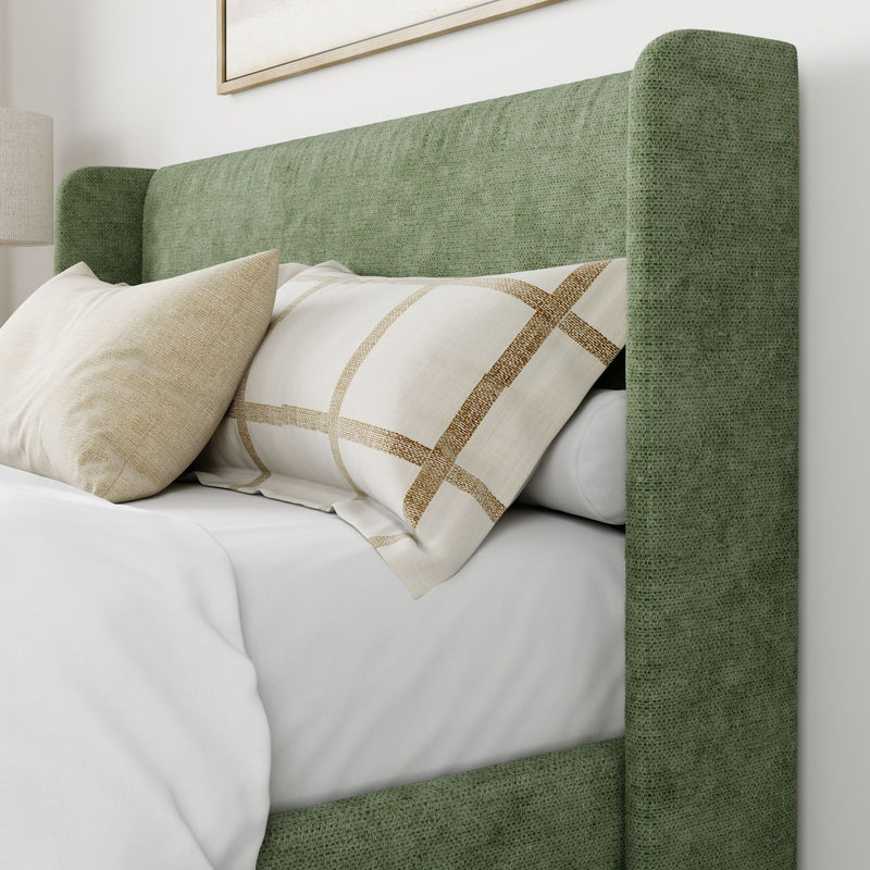 Luxurious green upholstered headboard with plush pillows in modern bedroom setting.