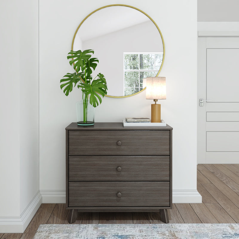 Modern wooden dresser with round mirror and decorative vase in a contemporary living room setting.