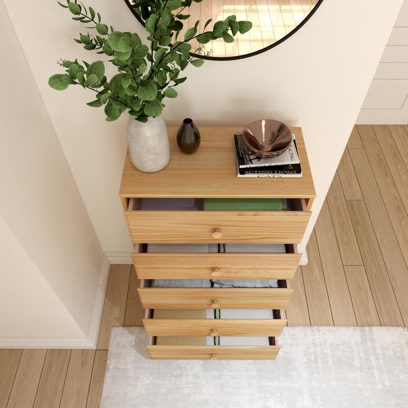 Top view of wooden dresser with plants and decor items in a modern bedroom setting