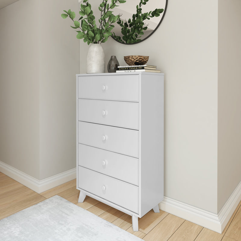 White wooden chest of drawers in modern bedroom with decorative plants and mirror.