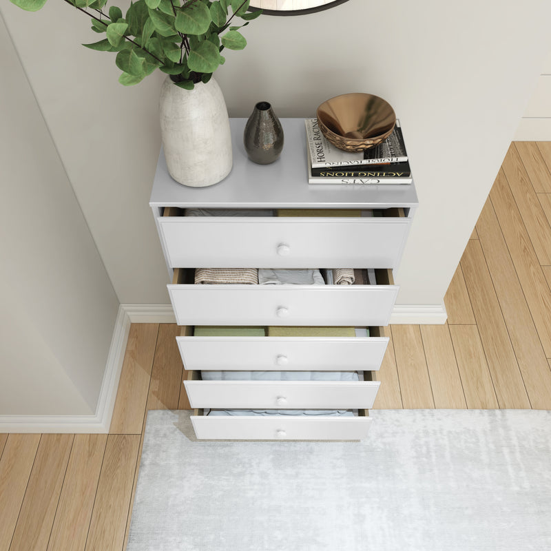 White chest of drawers with decorative vases and books on top, open showing organized clothes, on wooden floor with rug.