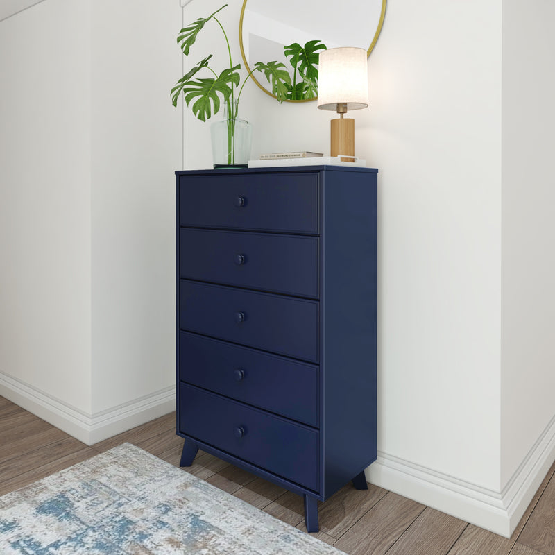 Modern navy blue dresser with five drawers in a stylish room corner, featuring a round mirror, a plant vase, and a decorative lamp.