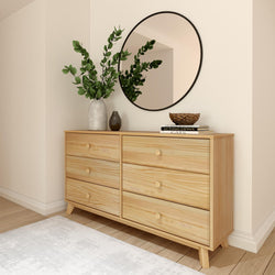 Modern interior with a wooden dresser, round mirror, and decorative plants for a stylish living room setup.
