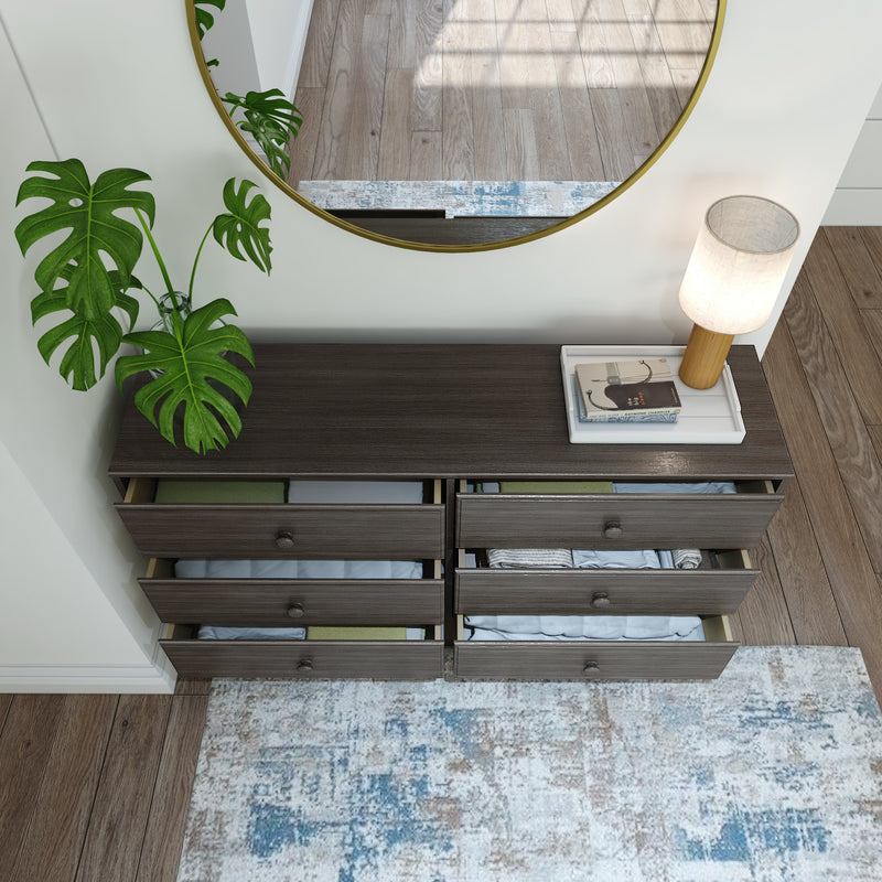 Modern dark wood dresser with open drawers, round mirror, and decorative lamp, showcasing stylish home interior design.