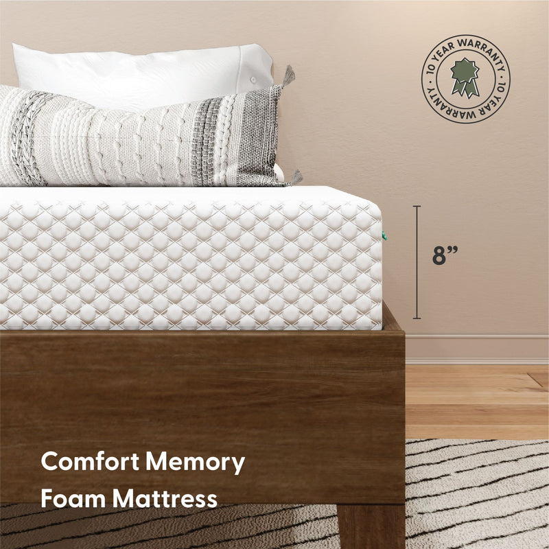 8-inch Comfort memory foam mattress with quilted white cover and textured decorative pillow on a wooden platform bed, 10-year warranty badge