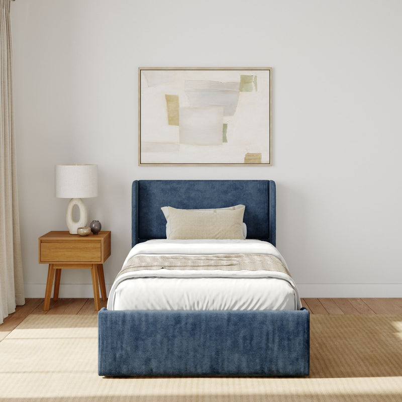 Contemporary bedroom with blue velvet bed, modern nightstand, and abstract wall art.