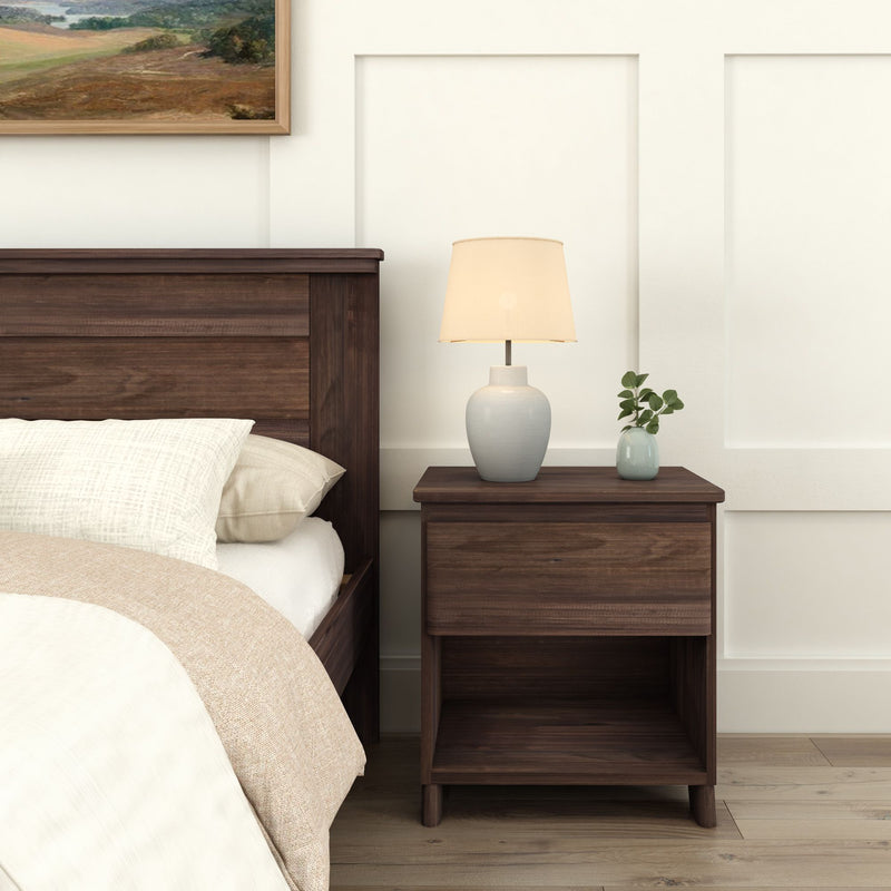Elegant bedroom scene with a wooden nightstand, ceramic lamp, and minimalist bedding.