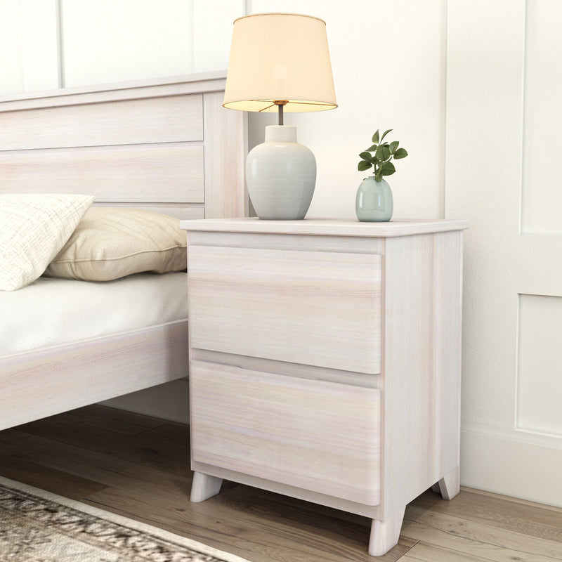 White bedside table with modern lamp and small plant in a cozy bedroom setting.