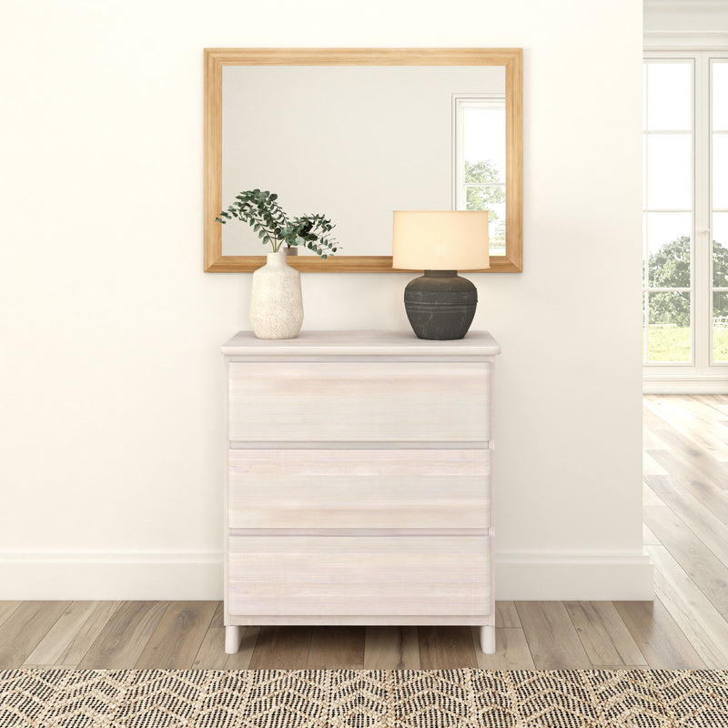 Modern white dresser with decorative vase and lamp in a cozy, minimalist living room setting.