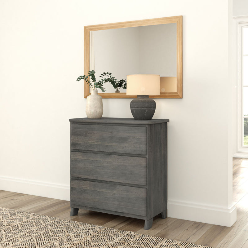 Gray wooden dresser with decorative vases and a lamp, placed beneath a large wooden-framed mirror in a bright, modern room.