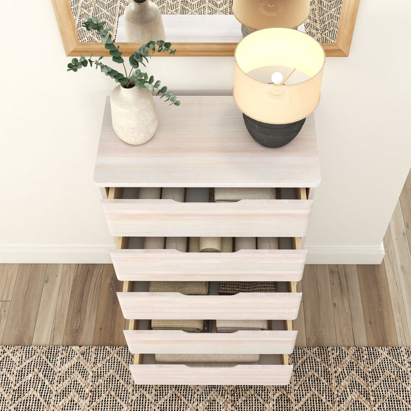 Stylish white chest of drawers with open drawers, topped with a vase and modern lamp, next to a decorative rug and mirror.