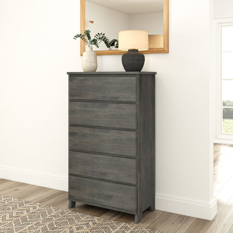 Dark wood chest of drawers with vases and lamp in modern bedroom setting.