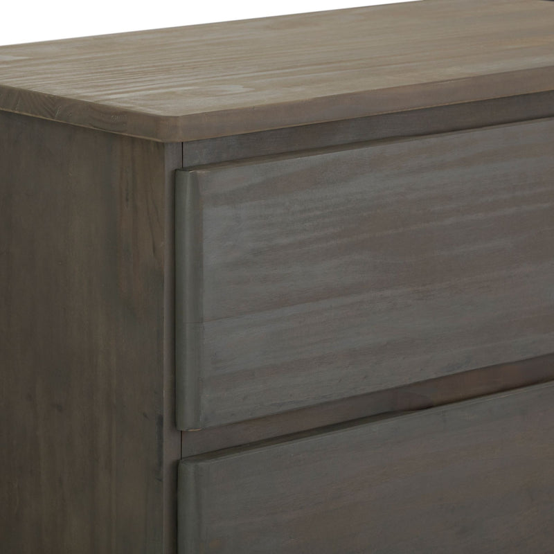 Close-up of the corner of a modern, dark wood dresser with a smooth finish.