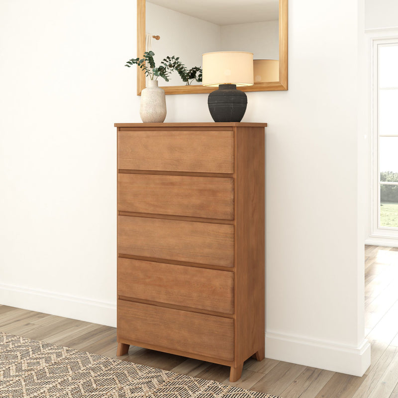 Wooden bedroom dresser with five drawers, topped with decorative vases and lamp, in a modern interior setting.