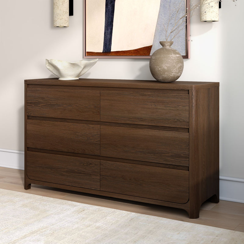 Modern dark walnut dresser with clean lines, styled with a white ceramic bowl, rustic textured vase and abstract framed art in a neutral contemporary room