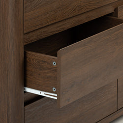 Close-up of a dark brown wood dresser drawer partially open showing wood grain finish and metal drawer slide hardware on modern bedroom furniture