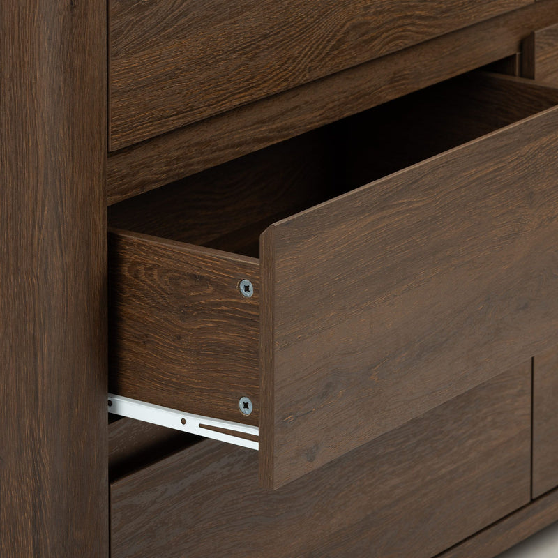 Close-up of a dark brown wood dresser drawer partially open showing wood grain finish and metal drawer slide hardware on modern bedroom furniture
