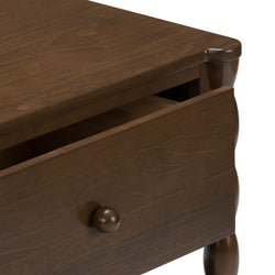 Brown walnut nightstand with partially open drawer, round wooden knob and turned legs, close-up showing wood grain and finish