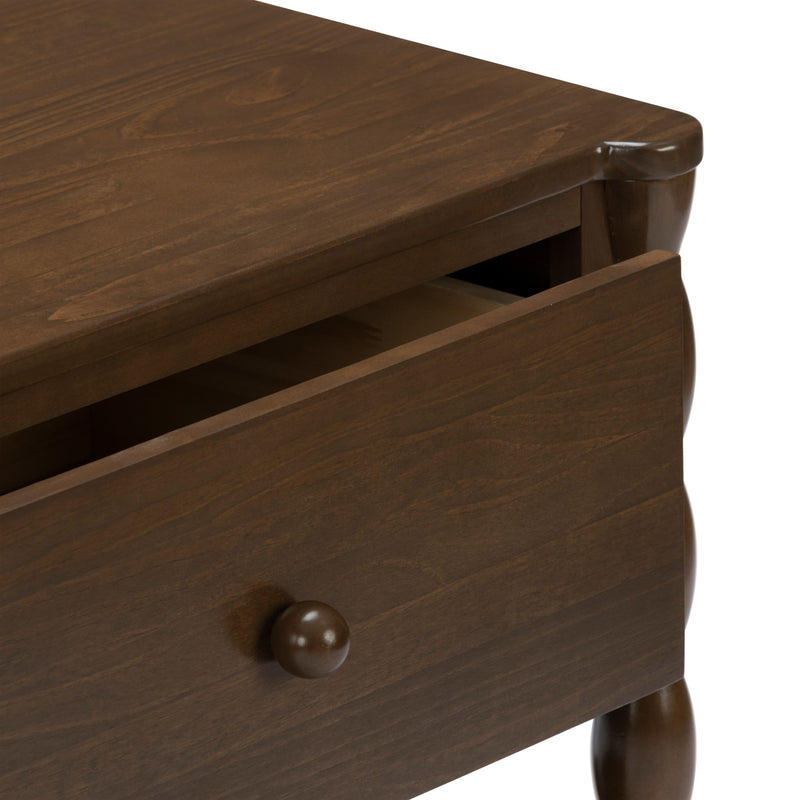 Brown walnut nightstand with partially open drawer, round wooden knob and turned legs, close-up showing wood grain and finish