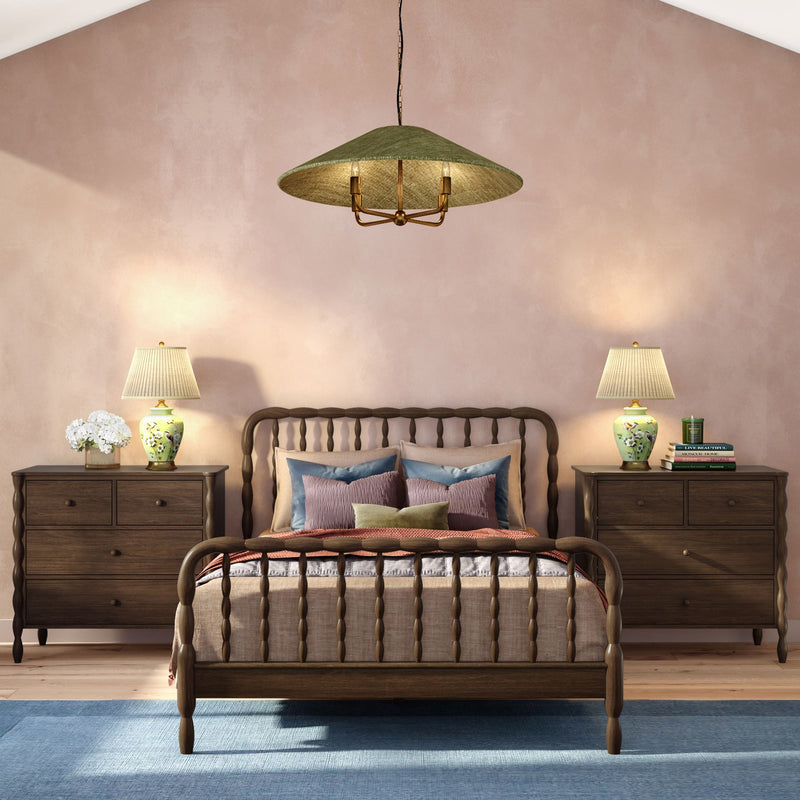 Cozy modern farmhouse bedroom with wooden spindle bed, matching dark wood nightstands, floral table lamps, pastel pink wall and blue area rug