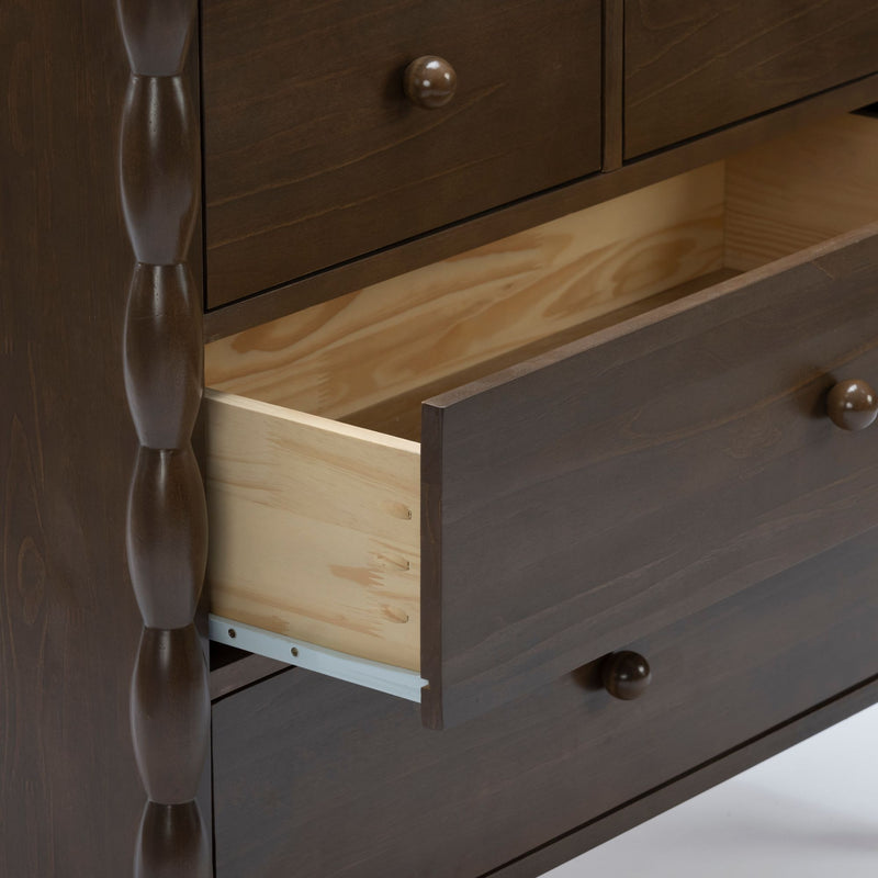 Dark brown wooden bedroom dresser with spindle side detail and open drawer revealing light pine interior and metal drawer slides