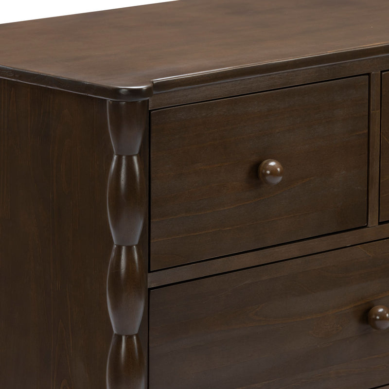 Close-up of dark brown solid wood dresser drawers with round wooden knobs and carved turned column detail, traditional bedroom furniture finish